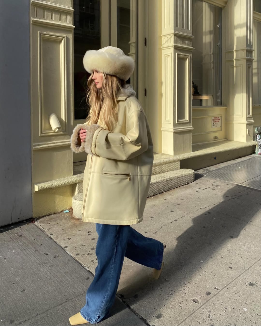 A woman with long, blonde hair wearing a big fluffy hat