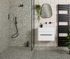 bathroom with terrazzo tiles, an organic mirror and black radiator