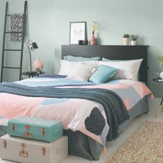pink and grey bedroom with trunks at end of bed