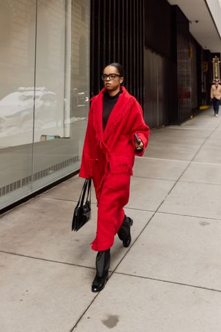 A street style image of a chic woman wearing an on-trend outfit on the streets of New York City during fashion week.