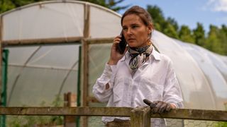 Virginie Ledoyen as Marie holds a phone to her ear in a garden in The Au Pair.