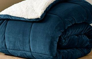 Deep blue weighted blanket folded up into bundle with shearling inside flapped out