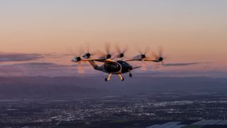 An aerial picture of the six-rotor Joby Aviation hydrogen-electric air taxi flying over California at sunset.