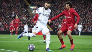 Karim Benzema of Real Madrid is challenged by Trent Alexander-Arnold of Liverpool FC during the UEFA Champions League round of 16 leg one match between Liverpool FC and Real Madrid