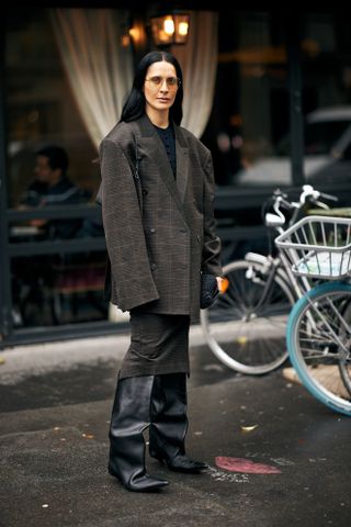 woman wearing slouchy boots in paris during fashon week