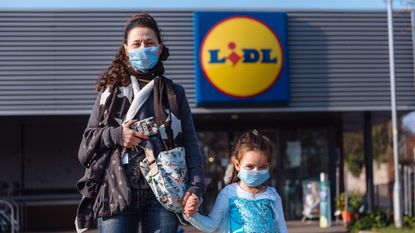 mother and daughter outside Lidl wearing masks