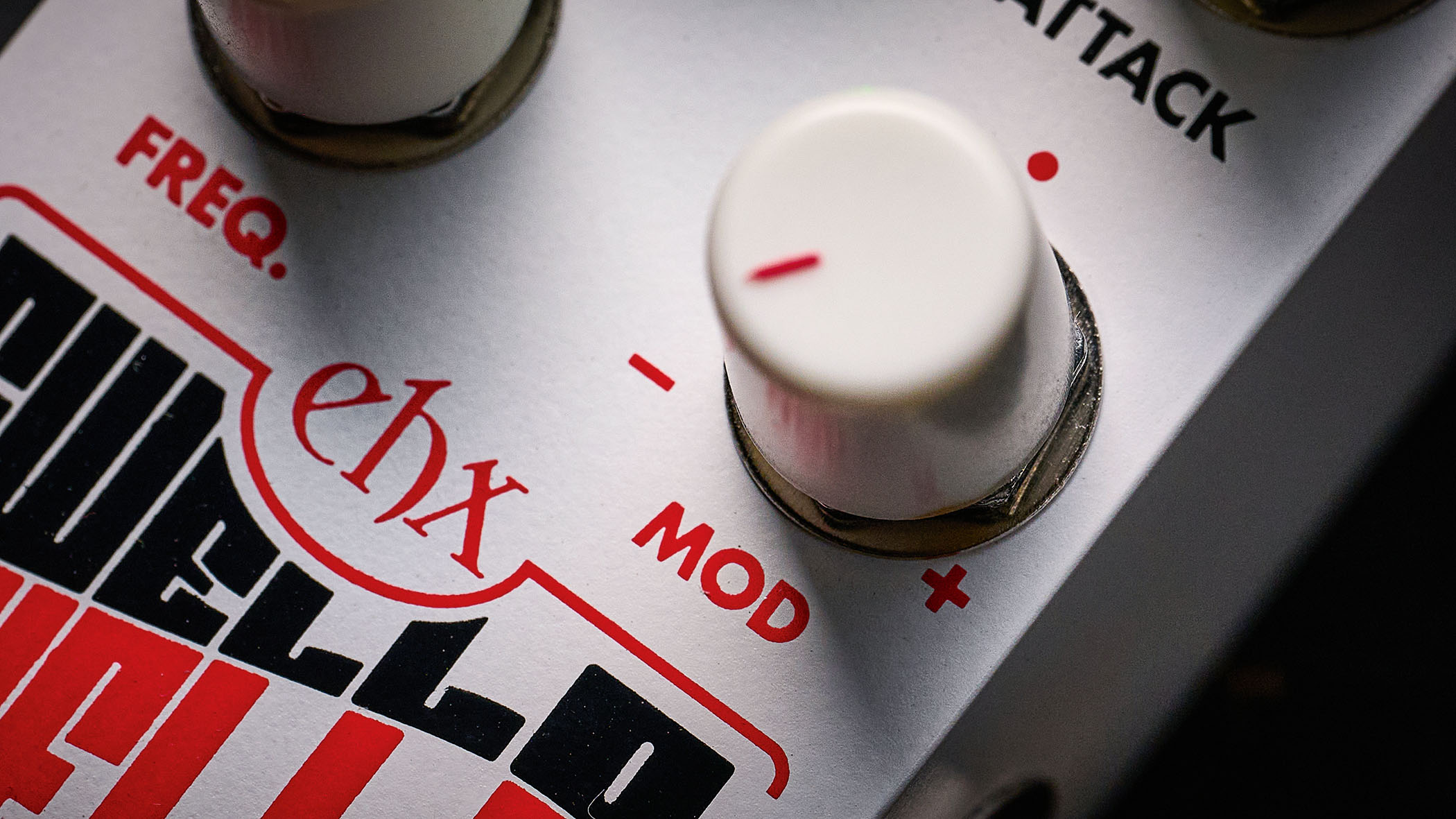 Electro-Harmonix Pico Swello: the compact mini-pedal is finished in white and has black and white text, four knobs, and is photographed against a distressed wood floor.