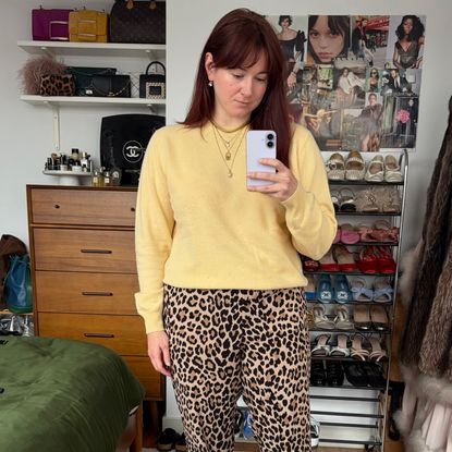 Tyler McCall wearing a yellow J.Crew men's cashmere crewneck sweater and leopard print pants.