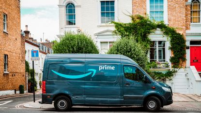 an Amazon Prime van parked in front of row houses