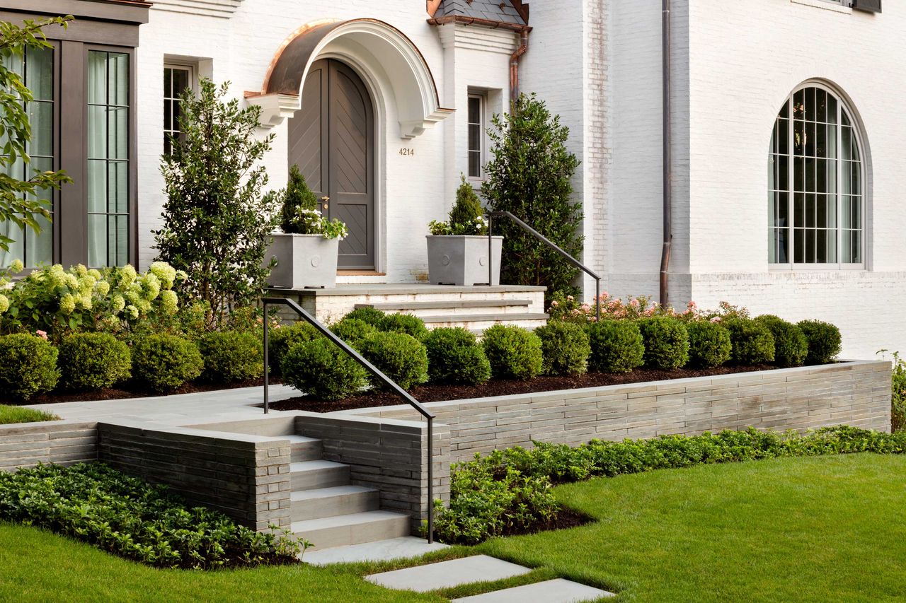 a front yard with small trees and shrubs