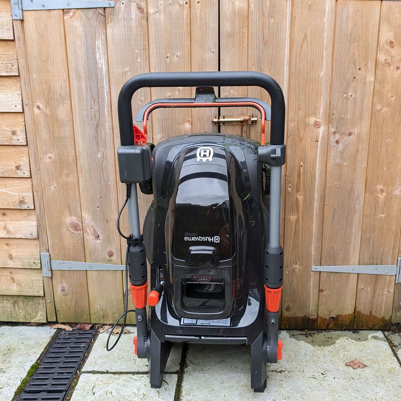 husqvarna aspire lc34 p4a folded by a shed door