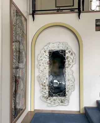 Mirror with transparent glass frame photographed on a blue staircase inside Gio Ponti's French villa