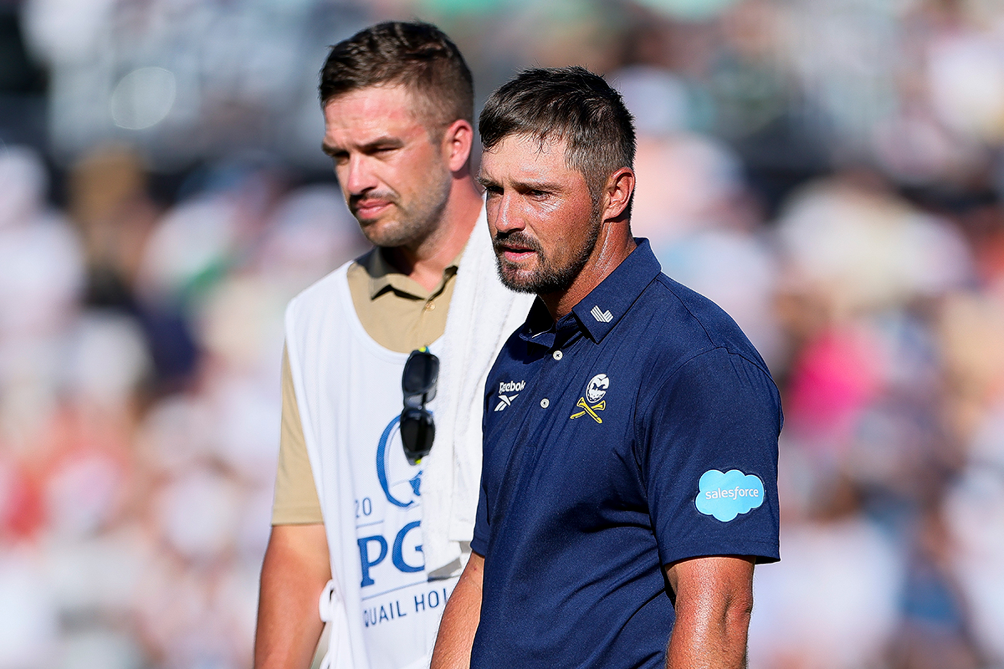 Bryson DeChambeau looking deflated with his caddie after failing to mount a serious charge at the PGA Championship at Quail Hollow