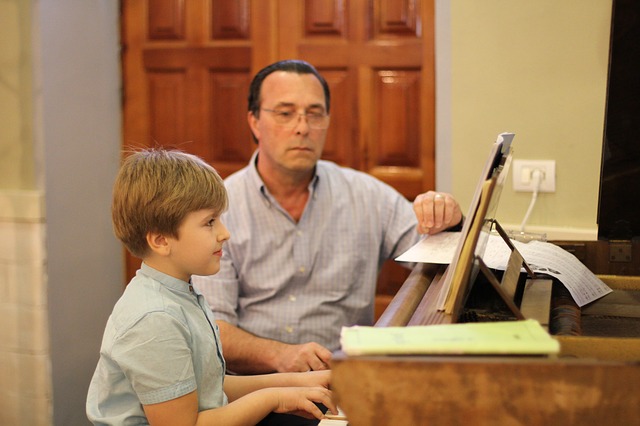 Ein Schüler lernt unter Aufsicht Klavier spielen