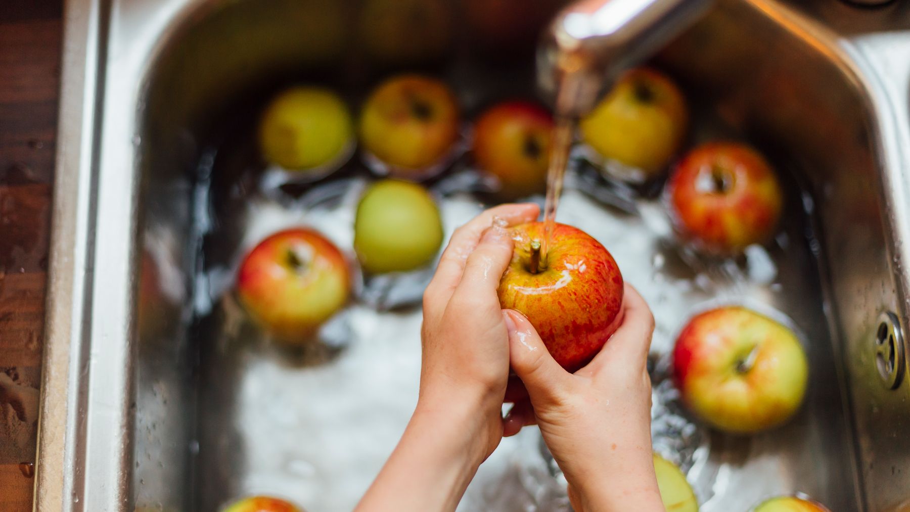 Apples being washed in the sink