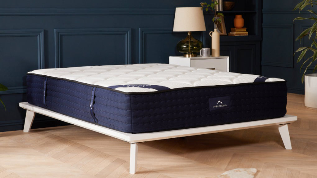 Image shows the DreamCloud Hybrid mattress, the brand's best mattress for most sleepers, in a stylish, well-lit bedroom