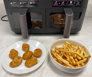Cosori Dual Drawer Air Fryer with nuggets and fries in front