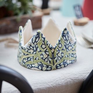 Fabric Christmas crown party hat on a white tablecloth