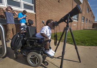 12th grade student Jay Hallman looks through a photographer's lens and solar filter to see the planet Mercury as it transited across the face of the sun on Monday, May 9, 2016, in, Boyertown, Pennsylvania.