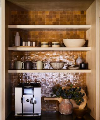 Coffee bar essentials in wooden hutch with glazed grid tiles in maroon and decorated shelving