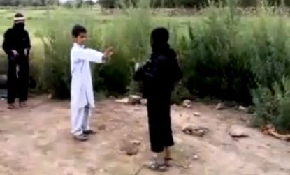 A young Pashtun boy shows his fake explosive vest to a "guard" before their suicide bomb game culminates in a dusty blast.