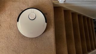 The Ecovacs Deebot X1 Omni next to a set of stairs