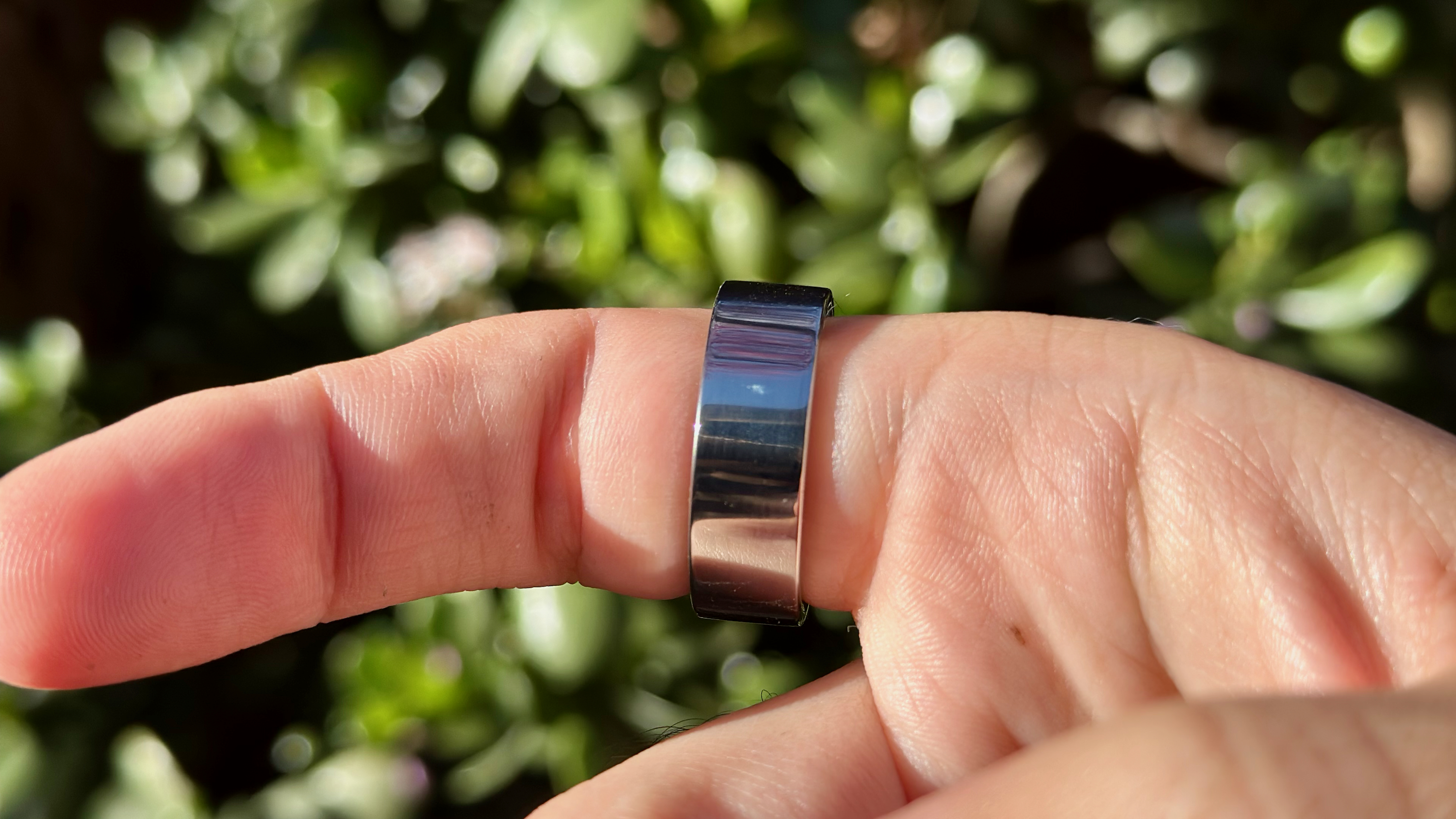 The Ultrahuman Ring Air worn on an index finger.