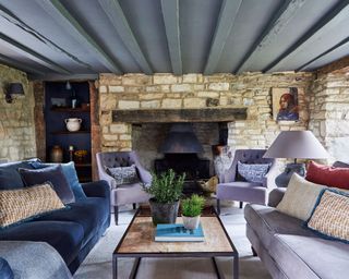 cosy modern country living room with exposed stone walls and inglenook fireplace