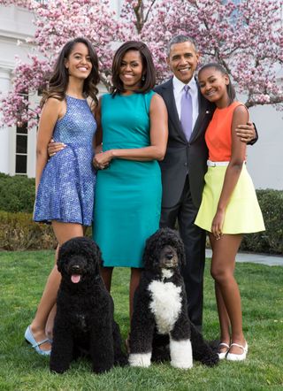 Michelle Obama, Barack Obama and daughters Malia (L) and Sasha (R) pose for a family portrait with their pets Bo and Sunny in the Rose Garden of the White House on Easter Sunday, April 5, 2015 in Washington, DC.
