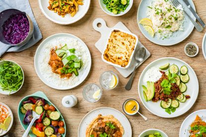 a dining table with several Jane Plan dishes such as pasta, curry and fish pie