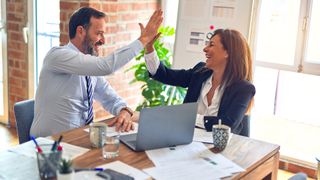 B2B Marketing example idea success: employees high fiving in a business meeting
