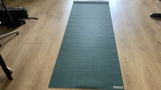 Jade Harmony Yoga Mat rolled out on wooden floor
