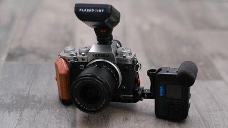 A GoPro sits mounted sidewise on a Fujifilm X-T4