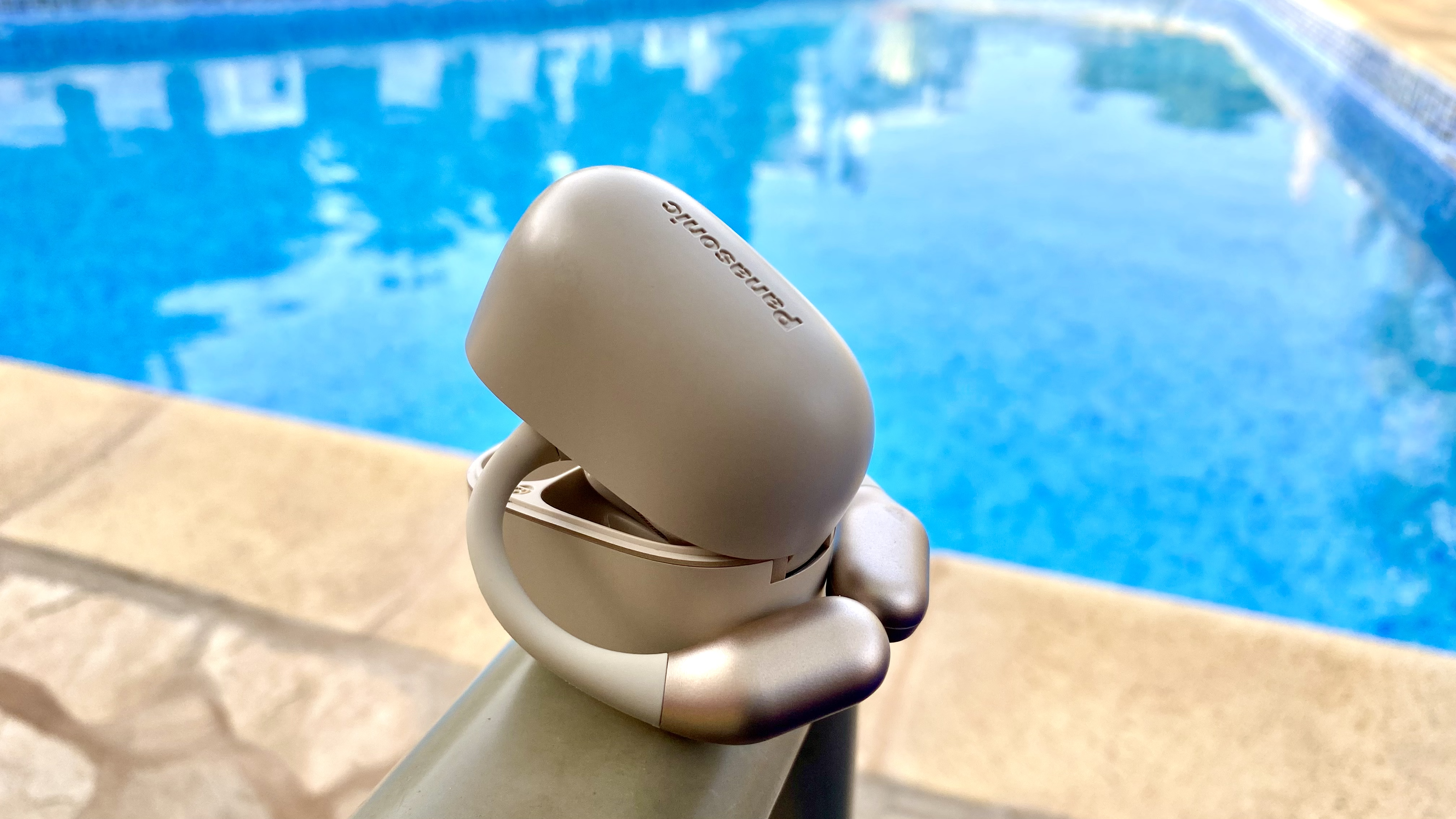 Panasonic RB-F10 open earbuds and carry case beside a swimming pool