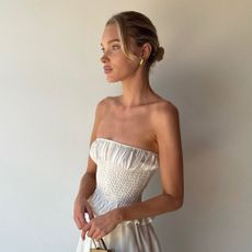 Elsa Hosk wearing a white jumpsuit with a The Row bag