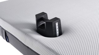 Image shows a heavy black weight placed near the edge of the Emma mattress during edge support testing