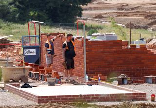 Construction workers lay bricks on a housing development in Hugglescote