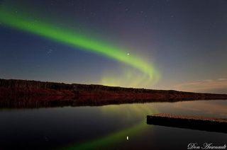 A wisp of aurora arcs over a serene lake in this spectacular photo captured by skywatcher and photographer Don Arsenault on Sept. 10, 2011 during a dazzling northern lights display.