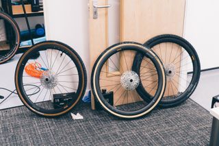 Three bike wheels leaning against a door in a lab