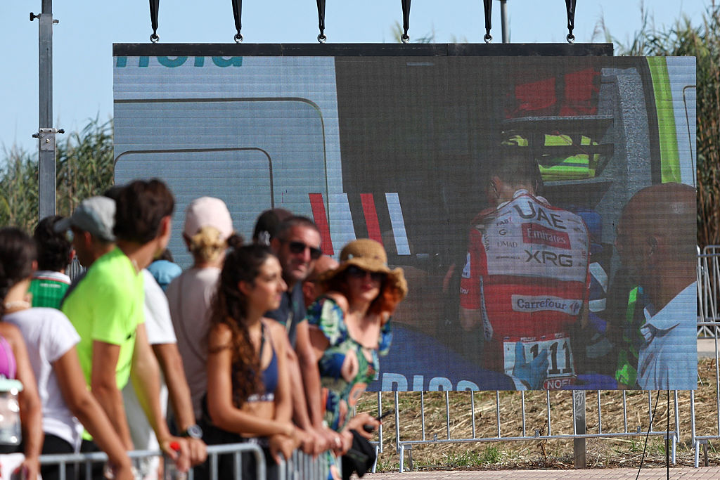 A screen shows Tadej Pogacar being ushered into an ambulance on stage eight
