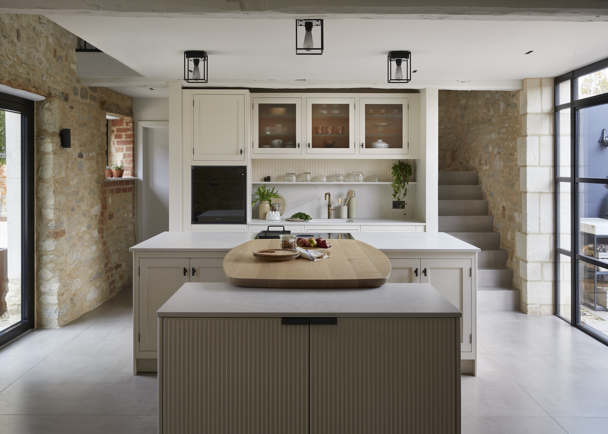 A double island layout with a curved wooden feature in the middle