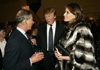 King Charles wears a suit while meeting Donald Trump and Melania Trump, who is wearing a fur coat and clutching a black bag, at the Museum of Modern Art in New York on November 1, 2005