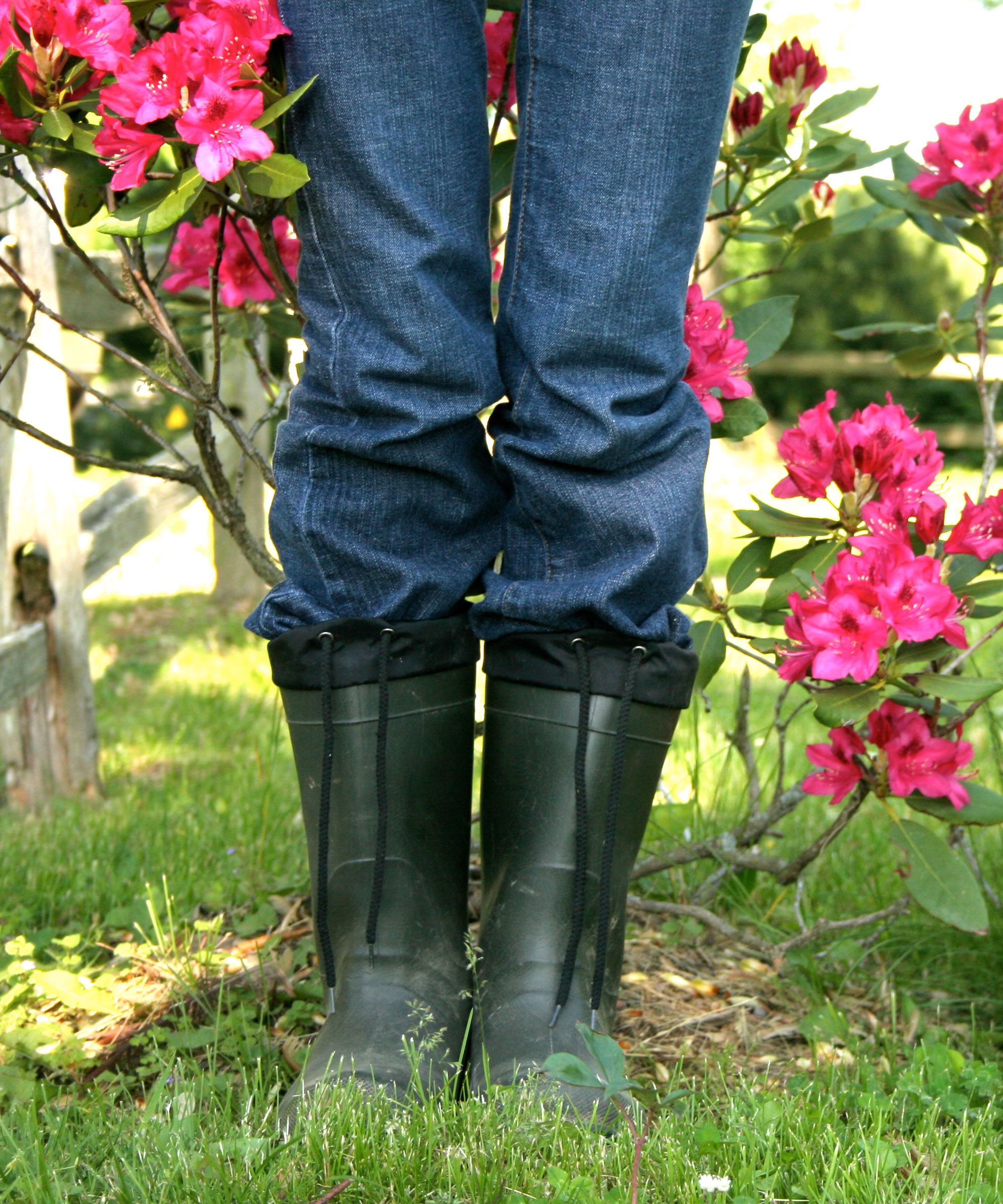 rhododendron bush with person standing in front of it in wellington boots