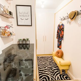 dressing room with white wardrobes, a zebra print rug and a yellow grand bench