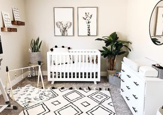 Nursery ideas in black and white, with white furniture and a geometric print monochrome rug.