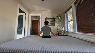 Our lead reviewer sitting on the edge of the Casper Original mattress