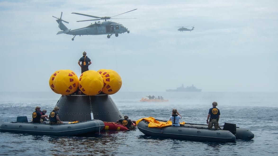 During Artemis 2 recovery simulations, helicopters from the U.S. Navy's Helicopter Sea Combat Squadron 23 "Wildcards" fly over a simulated spacecraft known as the Orion Crew Module Test Article on July 29, 2023. The exercise with the U.S. military and NASA took place off the coast of San Diego.