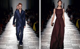 Side by side photos of male and female models walking along a catwalk. Male is wearing a black suit with open collar black shirt and loose fit trousers. The female is wearing a burgundy maxi dress with no sleeves and a clutch bag.