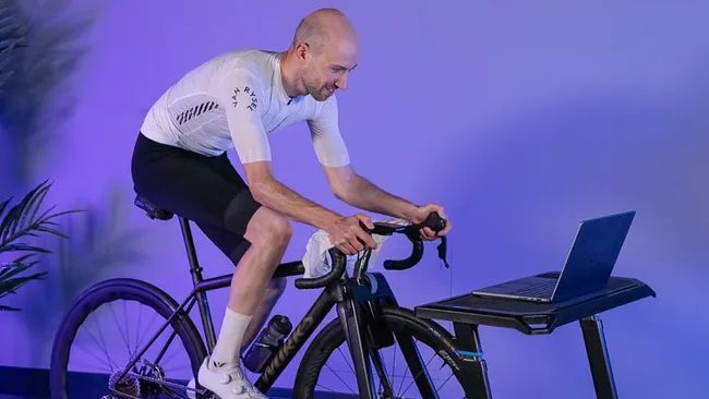 A male cyclist training indoors on MyWhoosh 