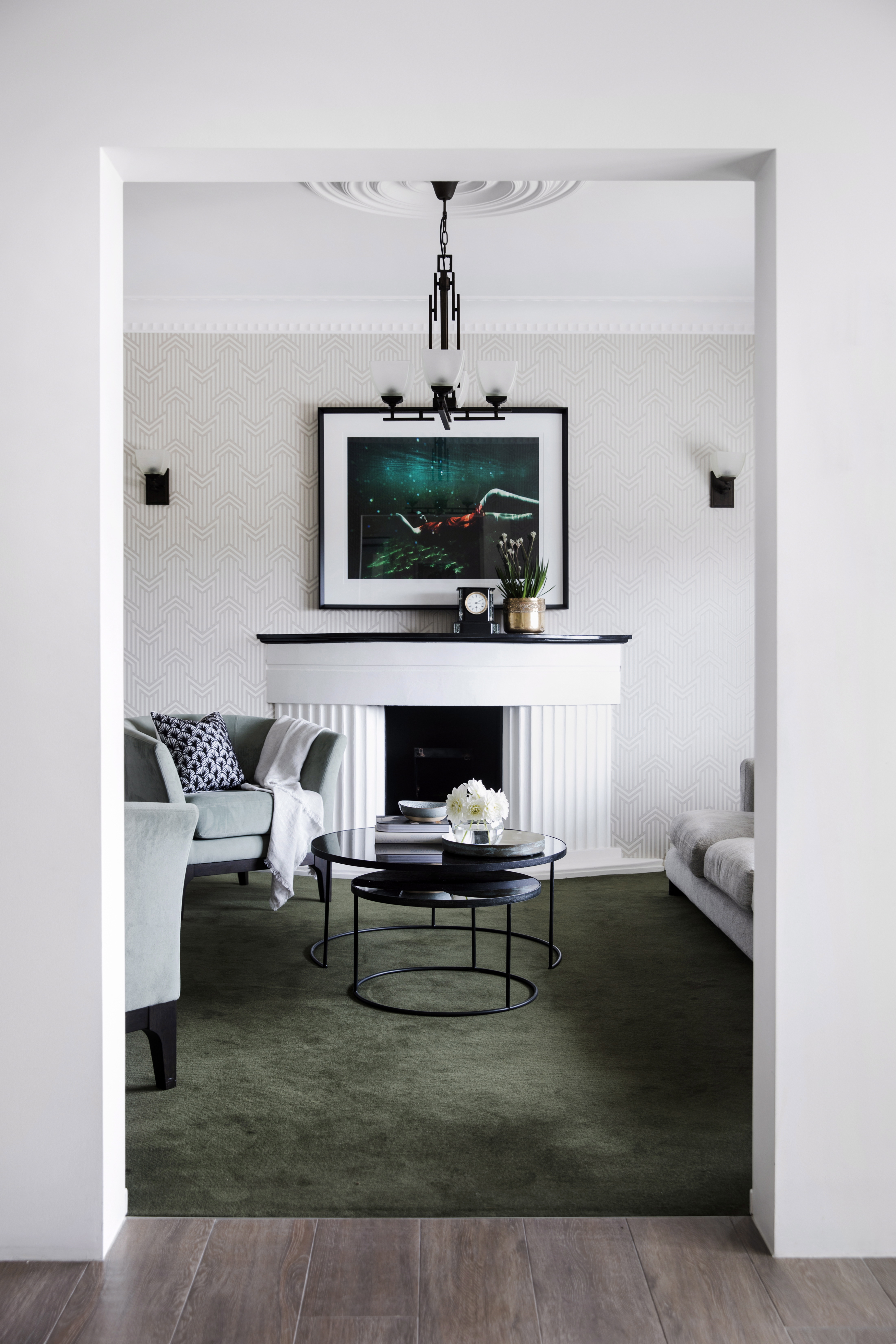 Green carpet in a living room space with art hanging on the wall and a coffee table in the center of the room.